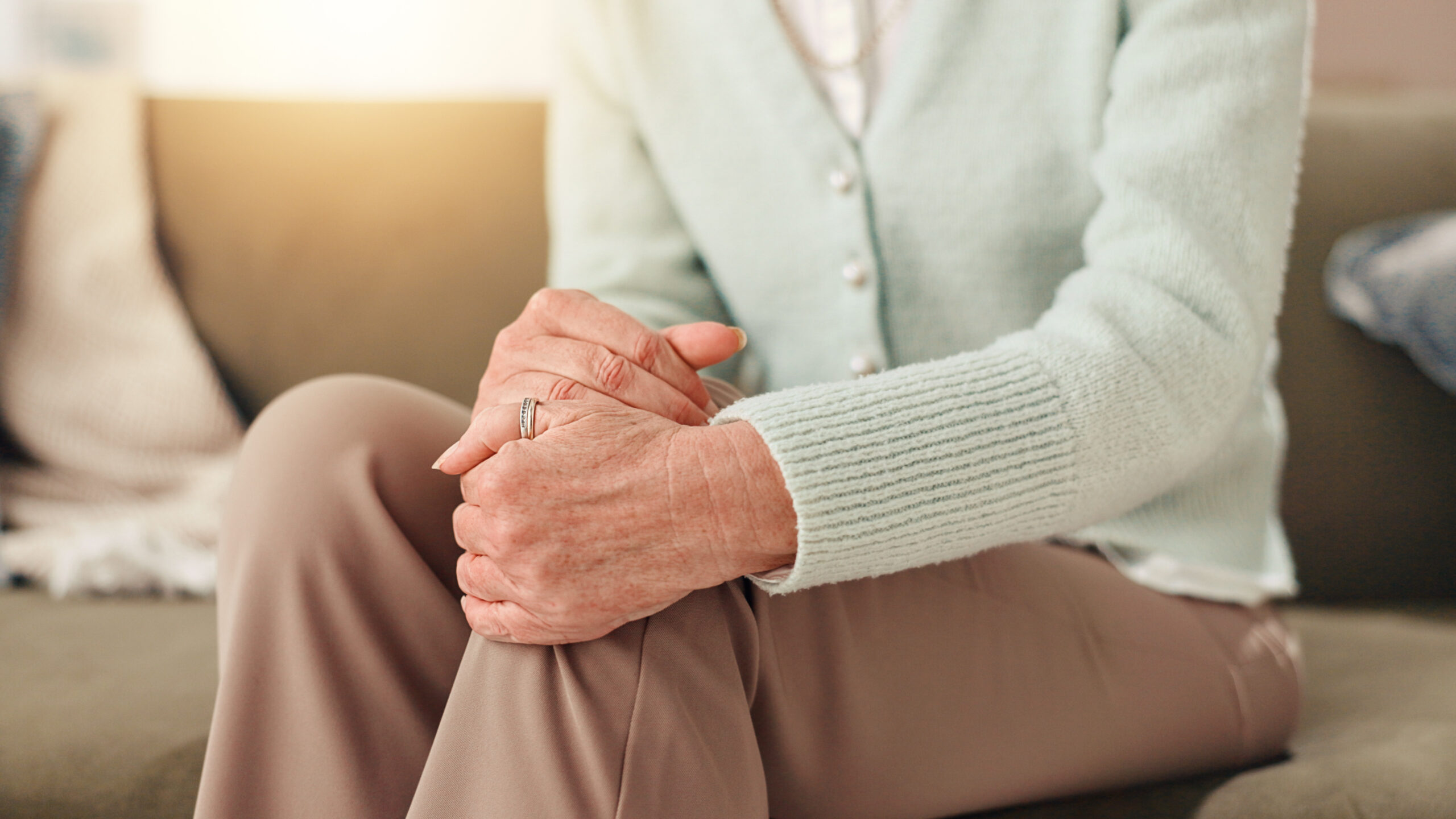 Knee pain, hurt and senior person with arthritis, stiffness and medical condition in home and hands. Healthcare, sore and pensioner with muscle tension, osteoporosis and massage for legs in house mobile wound care